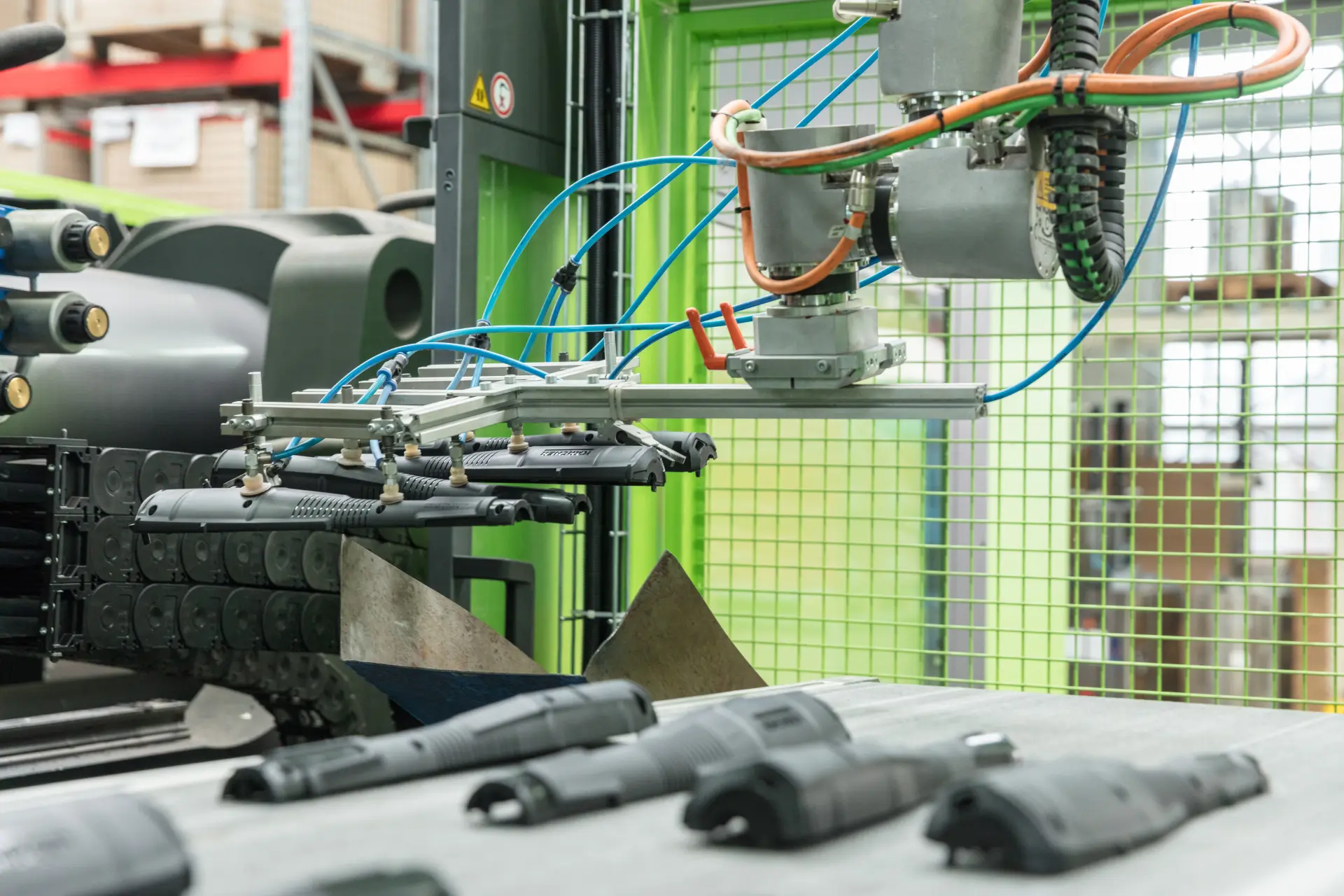 Robotic gripper with suction cups moving plastic parts on a production line.
